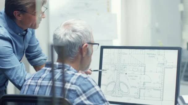 Dva starší architektonické inženýři pracující s budováním plán na osobním počítači. Aktivně diskutovat různé plány a schémata. — Stock video