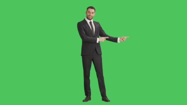 Μακρινό σουτ του ένας όμορφος χαμογελώντας επιχειρηματίας κάνοντας δάχτυλο όπλα / παρουσίαση χειρονομία. Φόντο είναι πράσινη οθόνη. — Αρχείο Βίντεο