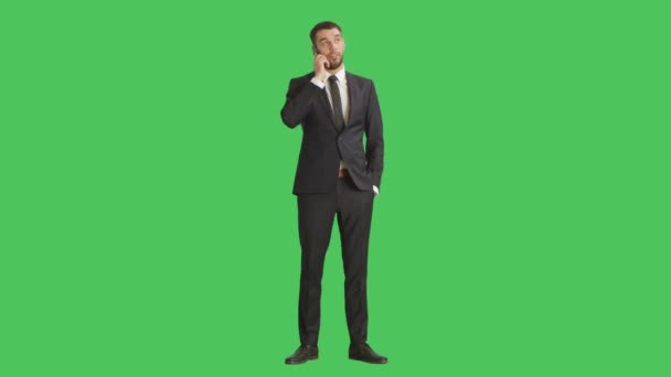 Hosszú lövés egy jóképű üzletember válaszol a telefon. Háttérben a Green Screen. — Stock videók