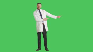 Bir yakışıklı bilim adamı yapma parmak silah atış / hareketi için ürün sunan uzun. Yeşil ekran arka plan üzerinde tüm çekim.