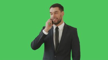 Orta atış ciddi düşünen işadamı kamera onun etrafında döner süre telefonda konuşuyor. Onun arka planı yeşil ekranıdır.
