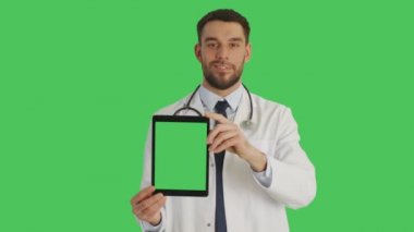 Gülümseyen bir doktor dikey olarak yeşil ekran Tablet bilgisayarınızla tutan orta vurdu. Yeşil ekran arka planı.