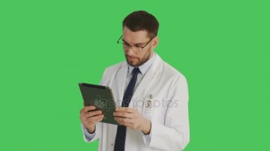 Bir gülümseyen yakışıklı bilim adamı yaptığı Swiping ve jestleri bir Tablet bilgisayarda dokunmadan orta vurdu. Yeşil ekran arka plan olduğunu.