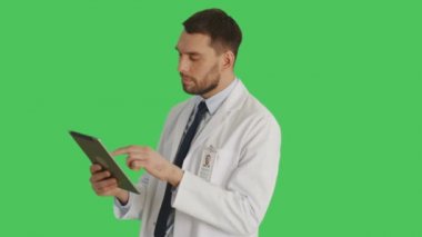 Tablet bilgisayar düşünme tutan yakışıklı bilim adamı orta vurdu. Kamera onun etrafında döner. Yeşil ekran arka plan olduğunu.