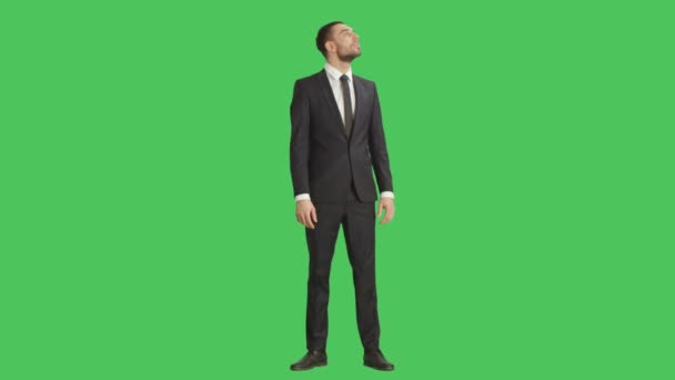 Длинный снимок красивого улыбчивого бизнесмена, забавно оглядывающегося. Снимок сделан на фоне зеленого экрана . — стоковое видео