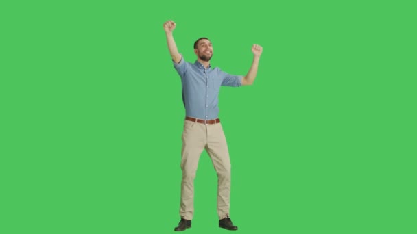 Largo tiro de un hombre casual bailando y divirtiéndose. Tiro en un fondo de pantalla verde . — Vídeo de stock