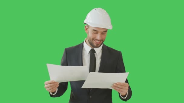 Medium Shot of a Successful Businessman wearing Hard Hat and Browsing through Charts Happily. Shot on a Green Screen Background. — Stock Video