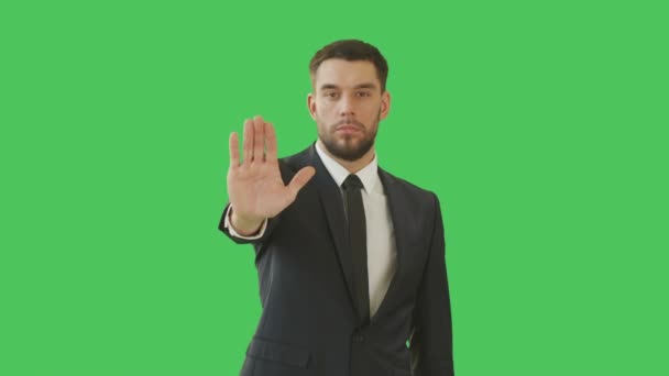 Średni strzał poważny biznesmen podejmowania znak Stop gest z jego strony. Strzał, odbywających się z zielonego ekranu tła. — Wideo stockowe