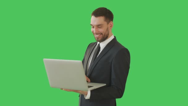 中景中英俊的商人拿着笔记本电脑使用触摸板。拍摄于绿色屏幕背景. — 图库视频影像