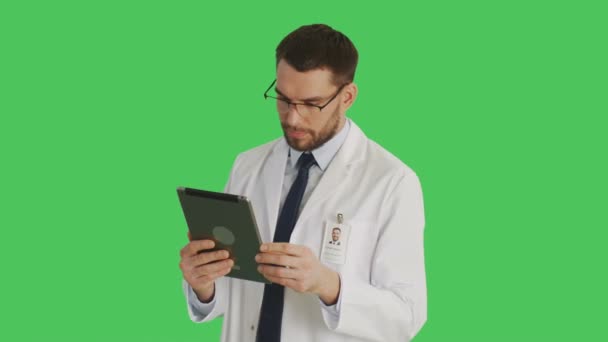 Bir gülümseyen yakışıklı bilim adamı yaptığı Swiping ve jestleri bir Tablet bilgisayarda dokunmadan orta vurdu. Yeşil ekran arka plan olduğunu. — Stok video