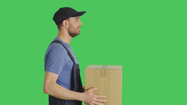 Profile Mid Shot of a Handsome Loader Handing in Cardboard Box. Shot with Green Screen Background. — Stock Video