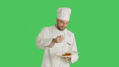 Yakışıklı bir şef Holding tabak çanak çanak bir kaşık ile dekorasyon ile orta vurdu. Yeşil ekran arka plan ile vurdu.