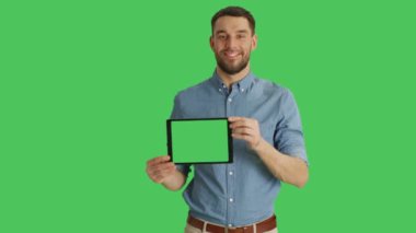 Yatay yeşil ekran Tablet bilgisayarınızla sunan üzerinde gülümseyen bir adam orta vurdu. Arka planda yeşil ekran.