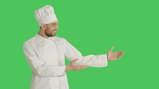 Mid βολή της ένας όμορφος σεφ παρουσιάζοντας χειρονομία. Φόντο είναι πράσινη οθόνη. — Αρχείο Βίντεο