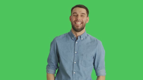 Mittendrin ein gutaussehender junger Mann, der lacht und Pistolenfinger macht. Hintergrund ist Green Screen. — Stockvideo