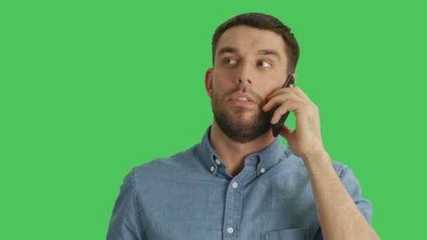 Nahaufnahme eines gut aussehenden Mannes, der am Telefon spricht. Sein Hintergrund ist Green Screen. — Stockvideo