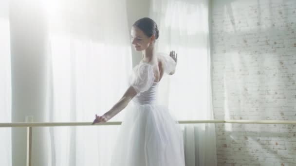 Mladá a krásná baletka ladně tancuje na její baletní střevíčky Pointe. Má na sobě bílé Tutu šaty. Studio je slunečné a moderní. V pomalém pohybu.