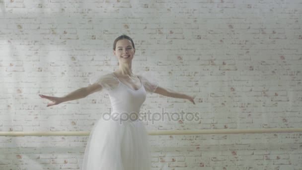 Bailarina joven y hermosa baila con gracia en sus zapatos de ballet puntiagudos. Lleva un vestido blanco tutú. Studio is Sunny and Modern. En cámara lenta . — Vídeos de Stock