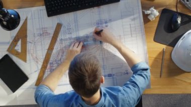 Üstten Görünüm planları üzerinde çizim onun planları üzerinde çalışan bir teknik mühendis. Çeşitli çizim nesneleri yalan onun masada.