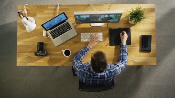 Bovenaanzicht van jonge getalenteerde fotograaf bezig met digitale Tablet tekenen op zijn bureaubladcomputer. De fotografie van het huwelijk van de verwerking. Zijn werk is bedekt met zonlicht. — Stockvideo