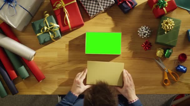 Draufsicht eines Mannes, der eine schöne Geschenkschachtel schließt. Box-Interieur ist eine grüne Bildschirm-Attrappe. — Stockvideo