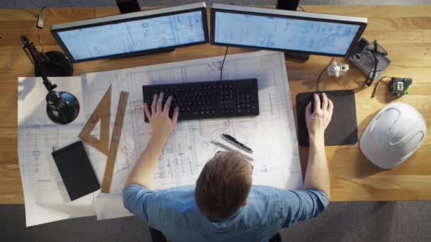 Top View of architectural Engineer Working on His Blueprints, Holding Tablet Computer, using Desktop Computer Also. Meja Nya penuh Objek Berguna dan Matahari Malam . — Stok Video