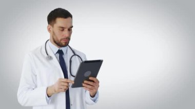 Tablet bilgisayar kullanarak bir doktor orta vurdu. Arka plan beyazdır.