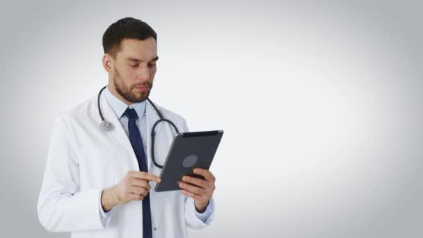 Tablet bilgisayar kullanarak bir doktor orta vurdu. Arka plan beyazdır. — Stok video