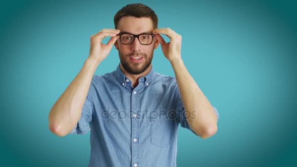 Mid Shot of Fashionable Handsome Man Correcting His Classes. Shot on a Teal Colored Background. — Stock Video