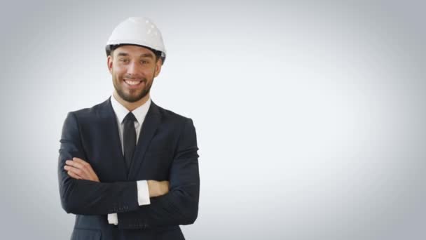 Средний снимок бизнесмена в жесткой шляпе, улыбающегося и скрещивающего руки. Сделано на белом фоне . — стоковое видео