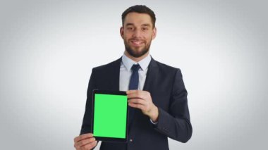 Yeşil ekran Mock-up Tablet bilgisayarınızla gösterilen gülümseyen bir işadamı orta vurdu. Beyaz arka plan üzerinde ateş.