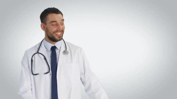 半ばジェスチャーを示す医師のショットと笑顔します。白い背景で撮影. — ストック動画