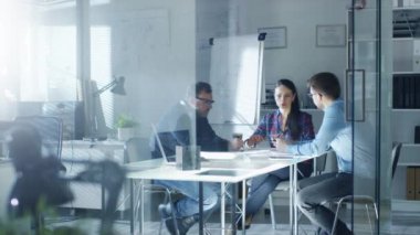 Tasarım mühendisleri toplantısı. Fikir alışverişinde ve planları oluyor. Arka plan beyaz tahta diyagramları, duvardaki planları ile içinde.