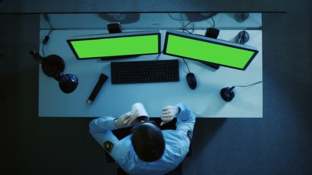 Vista superior de un guardia de seguridad mirando a los monitores de pantalla verde y hablando en Walkie Talkie. Trabaja de noche. . — Vídeos de Stock