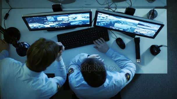 Vista superior de un guardia de seguridad y su pantalla Mirando a los monitores con video vigilancia y hablando en Walkie-Talkie. Trabaja de noche. . — Vídeos de Stock