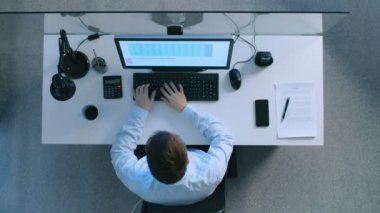 Onun kişisel bilgisayarda elektronik tablolarla çalışma onun masasında oturan bir ofis çalışanı en iyi görünümü. Önemli belgeler, masanın üstüne atma. Geç oldu akşam.