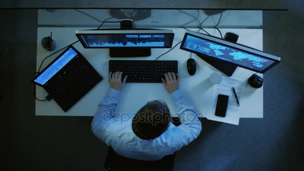 Top View of IT Specialist Working with Spreadsheets and Documents on His Laptop and Personal Computer одновременно. Куча бумаг на его столе. Это поздняя ночь . — стоковое видео