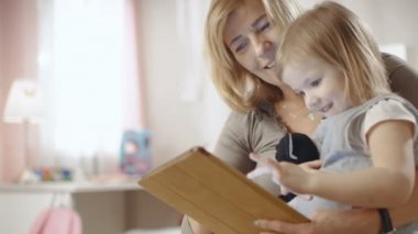 Sevimli küçük kız büyükannesinin kucağına oturur ve Tablet bilgisayar kullandıkları.