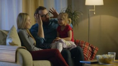 Akşam aile içinde zaman birlikte oturan bir kanepede bir oturma odasında geçiriyor. Küçük kız babasının kucakta oturur ve veliler onu gıdıklamak. 