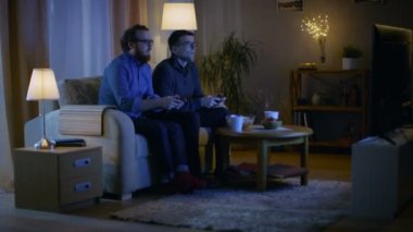 Akşam iki arkadaş salon ve Comptetitive Video oyunları oynarken bir kanepede oturuyor.