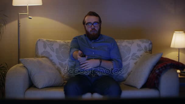 Ο άνθρωπος που κάθεται στον καναπέ στο σαλόνι — Αρχείο Βίντεο