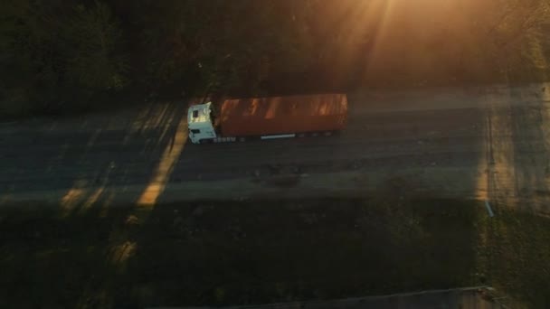 Tiro aéreo de um caminhão de contêiner se movendo em uma estrada rural ensolarada . — Vídeo de Stock