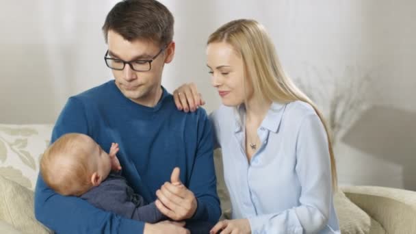 Glückliche Familie. Vater hält sein kleines Baby liebevoll in der Hand und gibt es dann seiner Frau. — Stockvideo