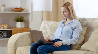 Genç güzel kadın onun oturma odasında oturuyordu ve onu Laptop çalışma.