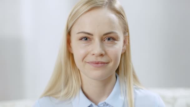 Portret Shot van een mooie jonge Blonde glimlachend in de Camera. — Stockvideo