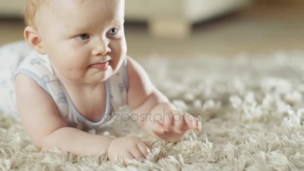 Nahaufnahme eines niedlichen kleinen Babys, das auf einem Teppich krabbelt. — Stockvideo