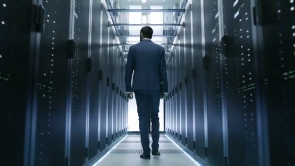 Following Shot of IT Engineer Walking Through Data Center with Rows of  Working Rack Servers on Both Sides. — Stock Video