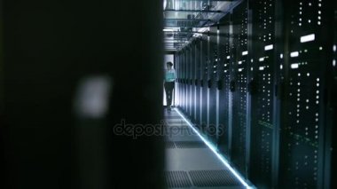 Kadın bu teknisyen ve erkek sunucu mühendisi yürüyüş ve ayarları bir çalışma veri merkezinin tartışmak. Kadın tutar Laptop.