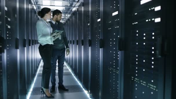 Male and Female Server Technicians Working in Data Center. Running Rack Server Diagnostics. Woman Uses Tablet Computer. — Stock Video