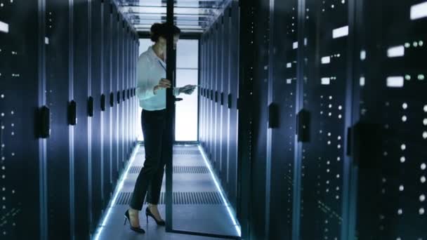 Kobiece inżynier pracę z tabletem w centrum danych. Ona zamyka drzwi gabinetu serwera. — Wideo stockowe